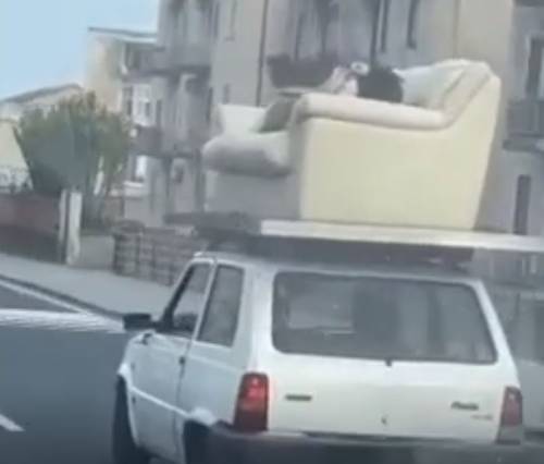 Viaggia sdraiato sul divano sul tetto di una Panda: follia tra le strade di Catania