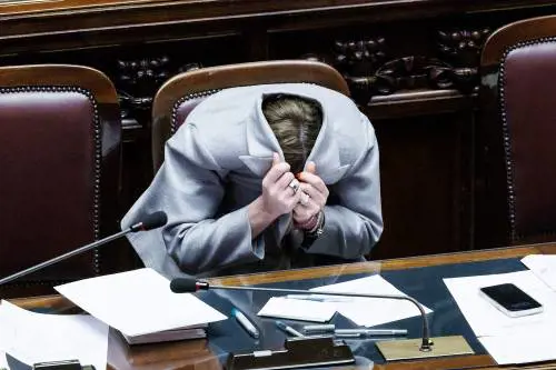 "Ha lo sguardo inquietante". E Meloni nasconde il volto nella giacca | Video