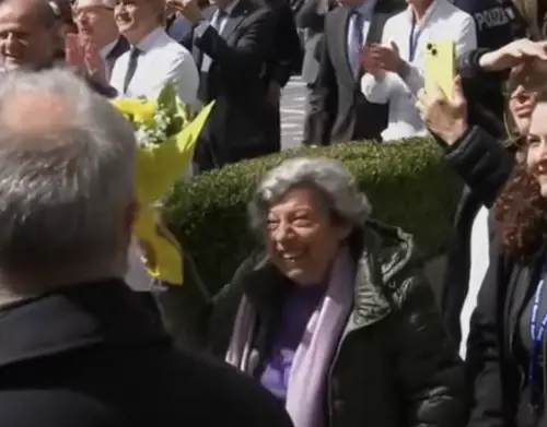 La signora Carmela con il mazzo di rose gialle mentre viene salutata da Papa Francesco