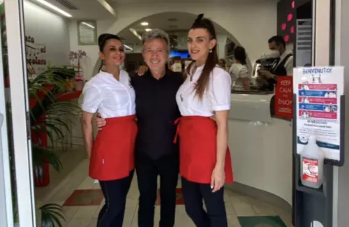 Il cantante Pupo insieme a due commesse della gelateria. Foto dal profilo Facebook