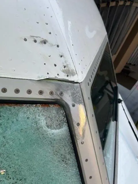 Il vetro in frantumi, il pilota ferito: le immagini del Boeing 737 colpito a 11mila metri