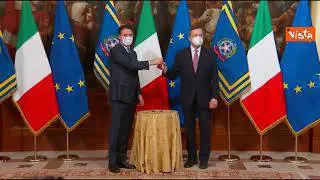 Il passaggio della campanella (con disinfettante) tra Conte e Draghi