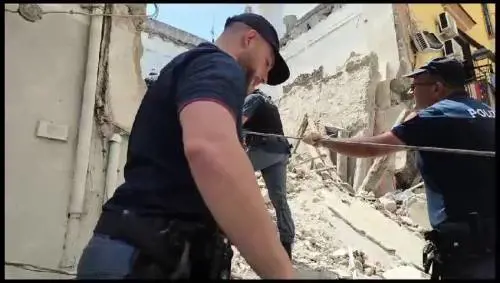 I soccorritori scavano tra le macerie della palazzina crollata