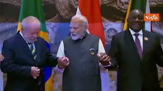 G20 in India, i leader si tengono per mano per la foto di gruppo, tra gli altri anche Modi e Biden