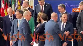 Meloni e Macron al Consiglio Ue si salutano con un bacio sulla guancia dopo la foto di gruppo