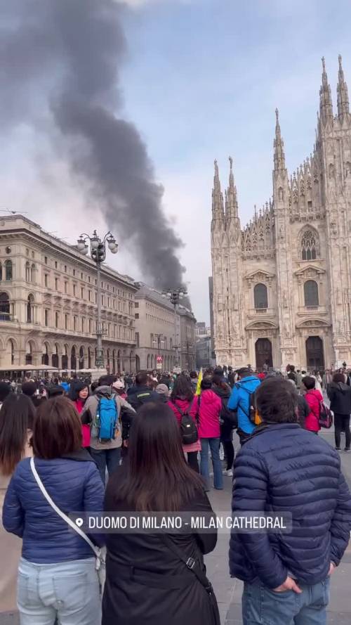 Il fumo dietro il Duomo ripreso dei turisti a Milano