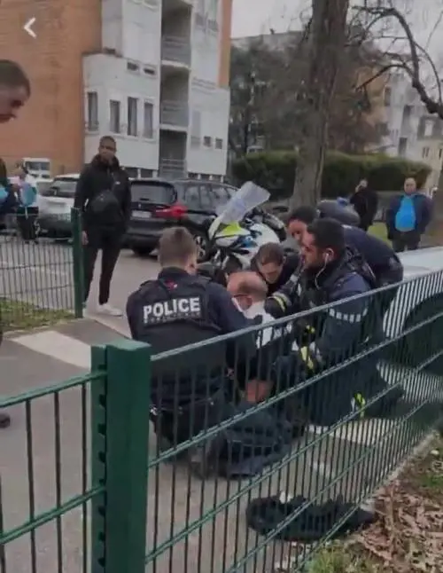 La polizia cura uno dei feriti dell'attentato a Mulhouse