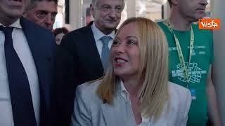 Meloni arriva al Meeting di Rimini accolta dagli applausi. Poi autografa il suo libro a un fan