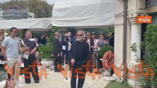 "Buongiorno", Christoph Waltz saluta i fotografi al suo arrivo al Lido per Venezia 82
