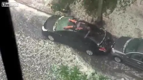 Si sdraia sulla macchina per proteggerla dalla grandine
