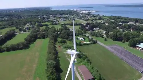 In cima alla pala eolica, un uomo prende il sole