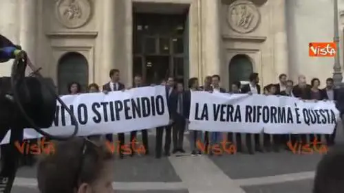 Lo striscione a Montecitorio. "Tagliatevi lo stipendio, la vera riforma è questa"