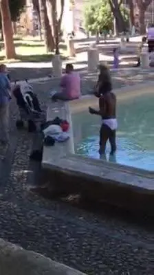 Roma, migrante si lava nel parco  di Colle Oppio