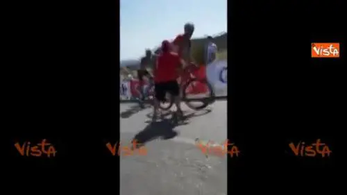 Spettatore perde la testa e spinge un ciclista fuori strada durante una gara