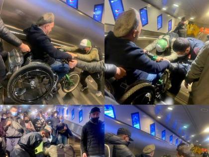 A Roma le scale mobili sono fuori uso e un uomo su sedia a rotelle viene portato in spalla