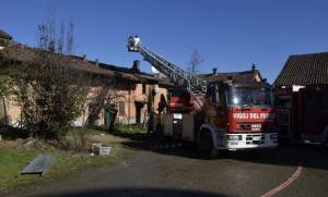 I vigili del fuoco lavorano, dopo avere domato l'incendio, nella  cascina