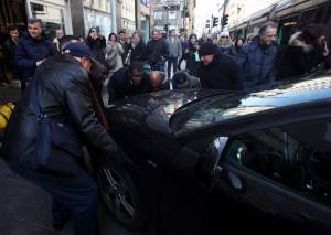Milano, auto in sosta selvaggia: la folla la sposta di peso dai binari