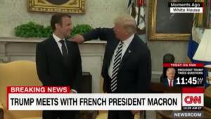 Trump toglie la forfora dalla giacca di Macron