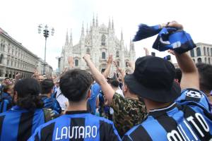 Davanti al Duomo di Milano tra cori, bandiere e sfottò