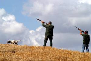 Parroco benedice i fucili dei fedeli per l'inizio della caccia