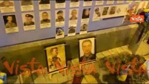 Un bambino tocca una foto sul muro degli eroi di Kiev ed esclama: Papà