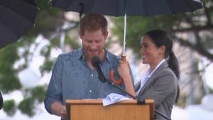 Meghan ignora il protocollo e tiene l'ombrello al marito