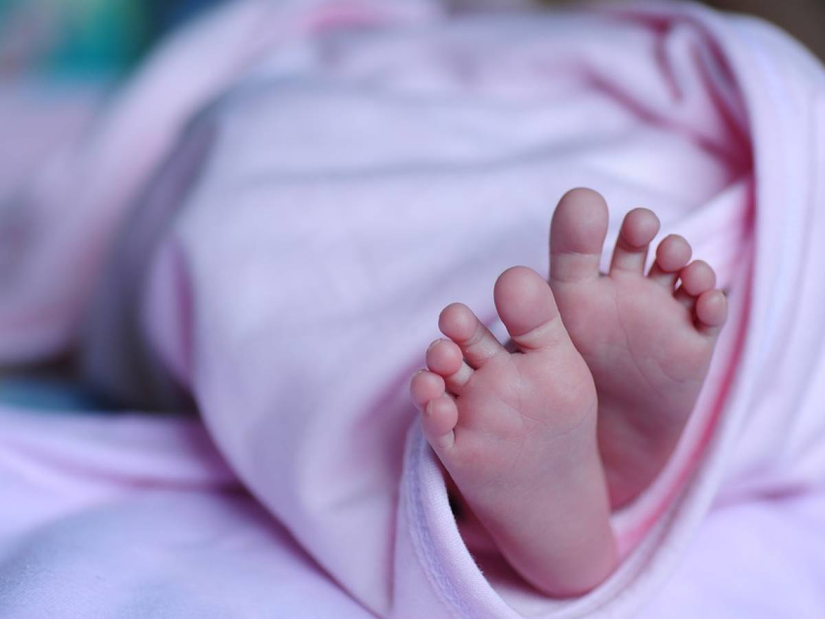 Piccola bambina neonato in un rompero viola. bambino di 9 mesi. Traguardo  di nove mesi per il bambino Foto stock - Alamy