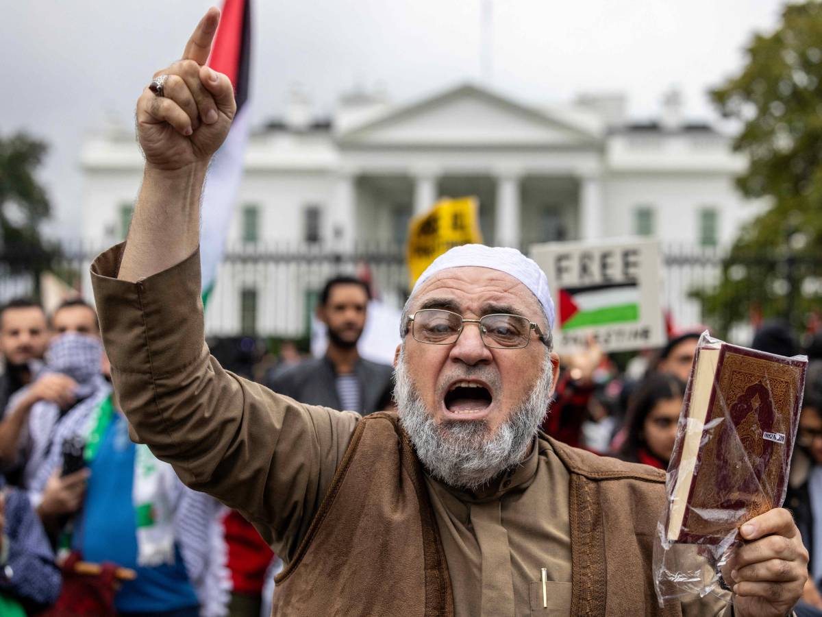 Un uomo mostra il corano e protesta contro Israele davanti alla Casa Bianca