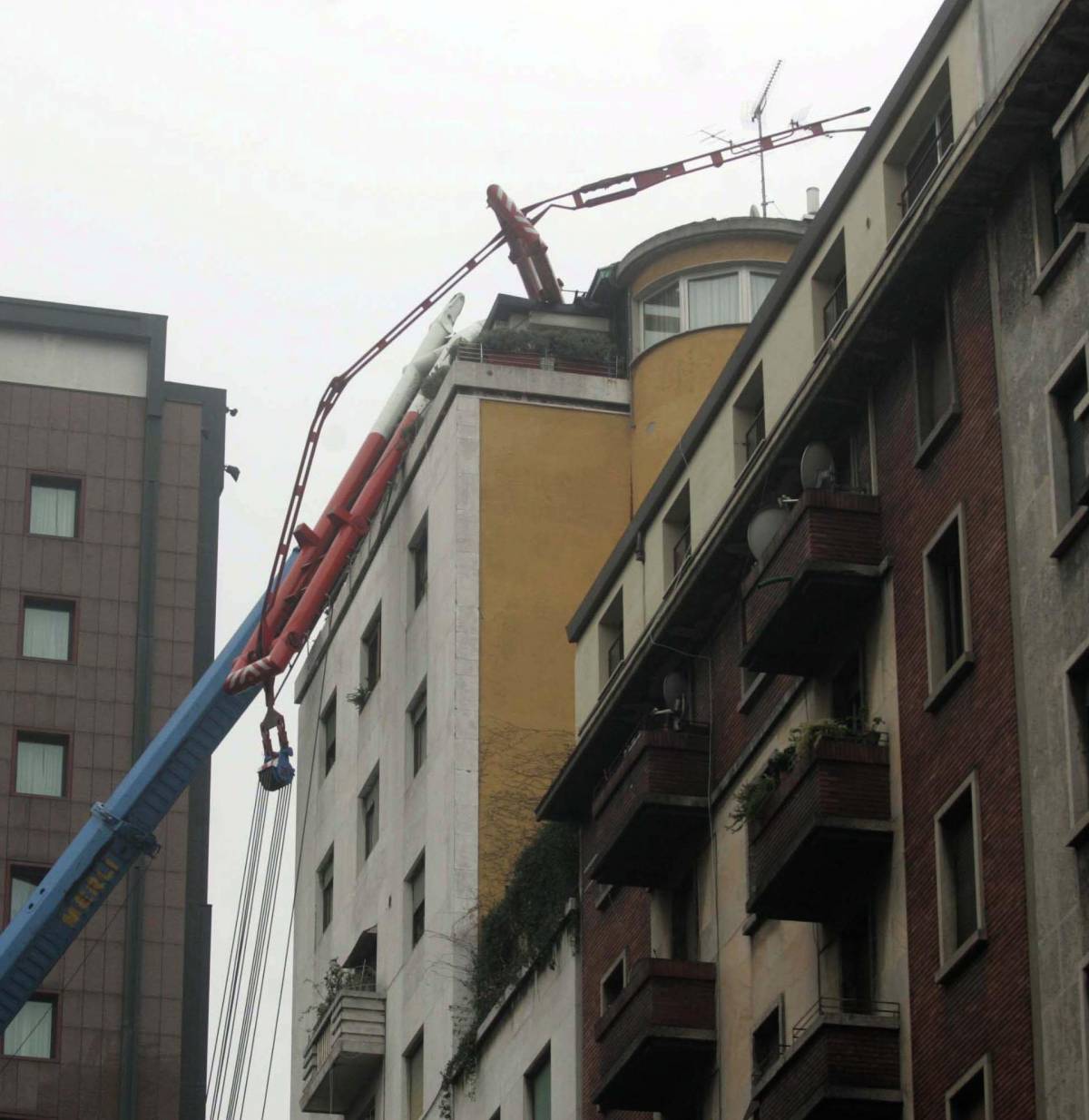 La maxi gru si schianta sul tetto di un palazzo: «Sembrava una bomba»