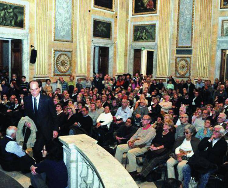 Seduti in terra per ascoltare la storia di Genova