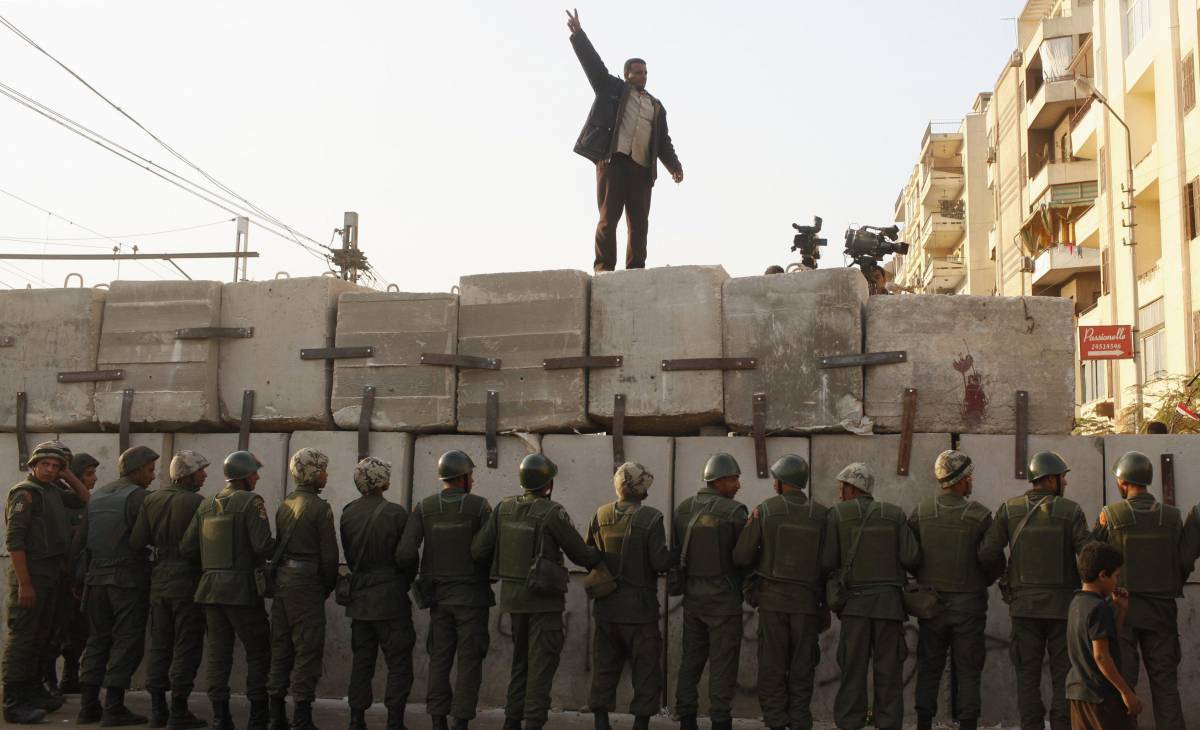 Un manifestante anti Morsi di fronte a una fila di soldati schierati al Cairo