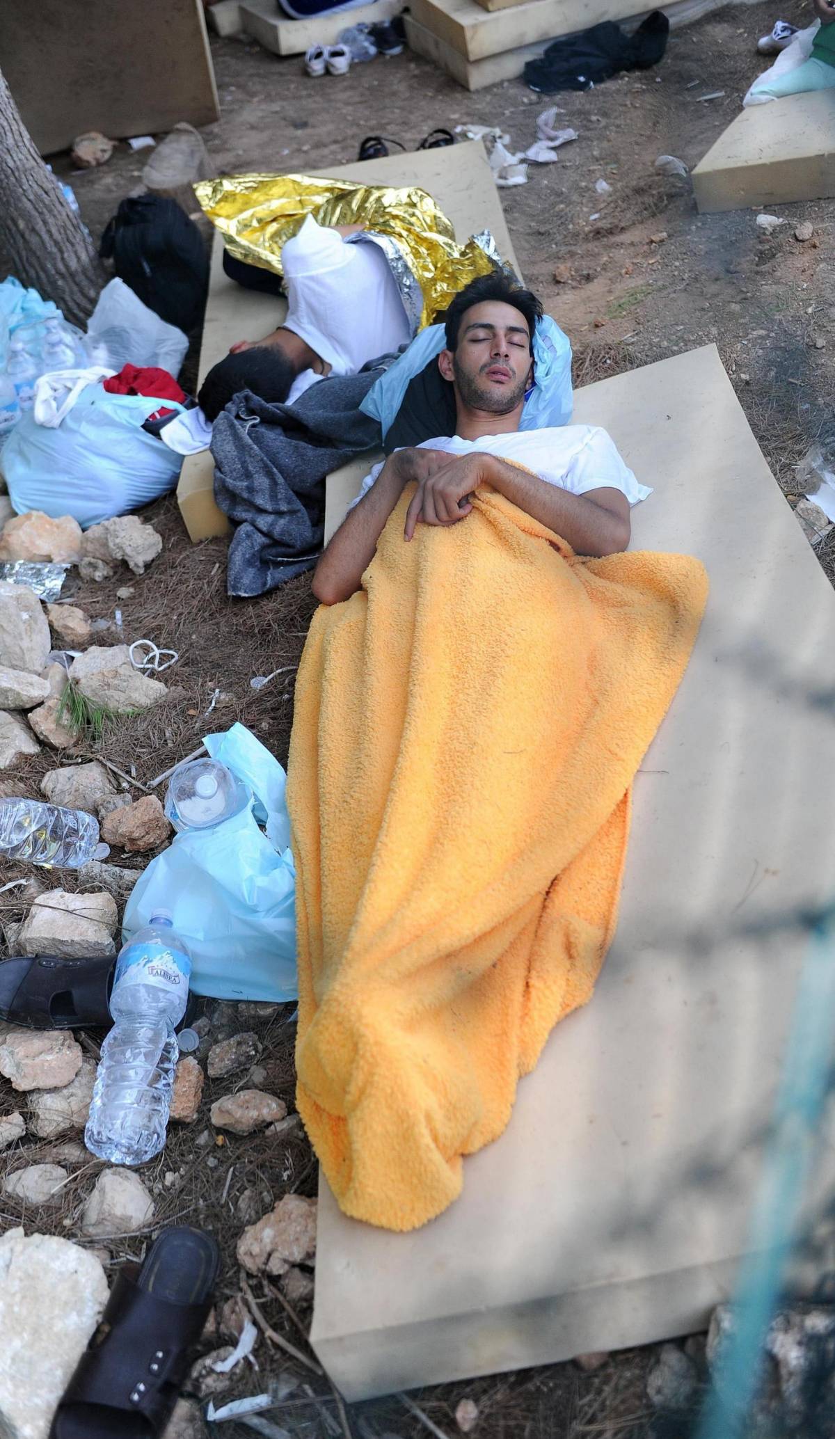 Un migrante dorme nel Centro di prima accoglienza di Lampedusa