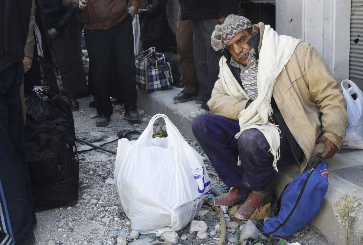 Civile in attesa di essere evacuato dalla città di Homs
