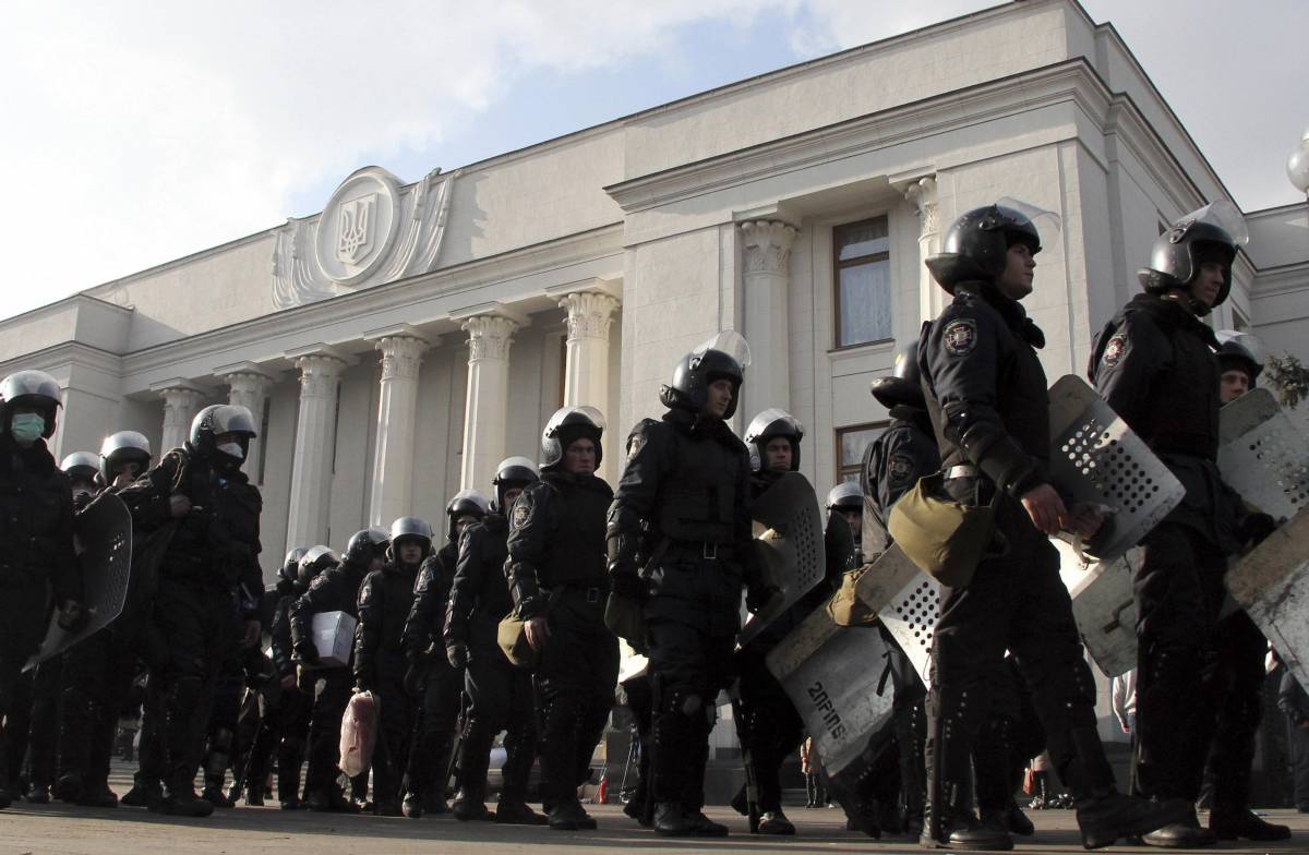 Un gruppo di poliziotti in tenuta anti-sommossa si allontana dal Parlamento ucraino