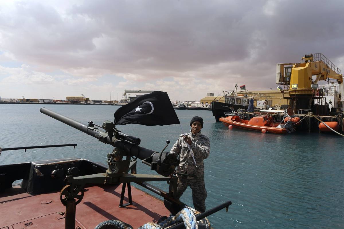 Un ribelle al porto di Sidra. In mano la bandiera della Cirenaica