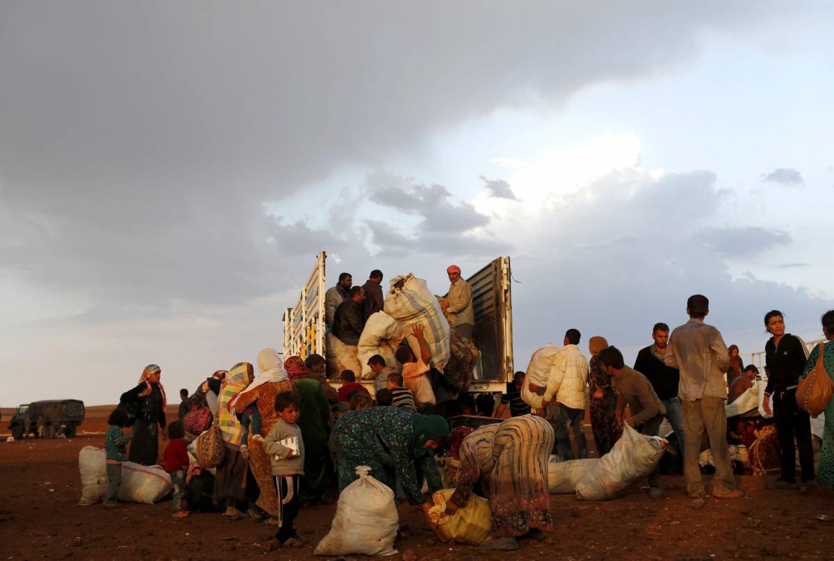Un gruppo di profughi lascia la Siria attraverso il confine turco