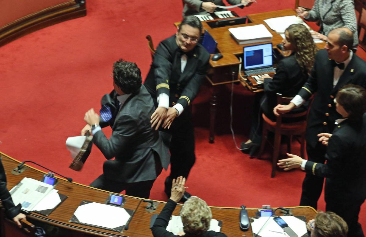 Il senatore Maurizio Buccarella del M5S fa uno scatto per sfuggire dai commessi 