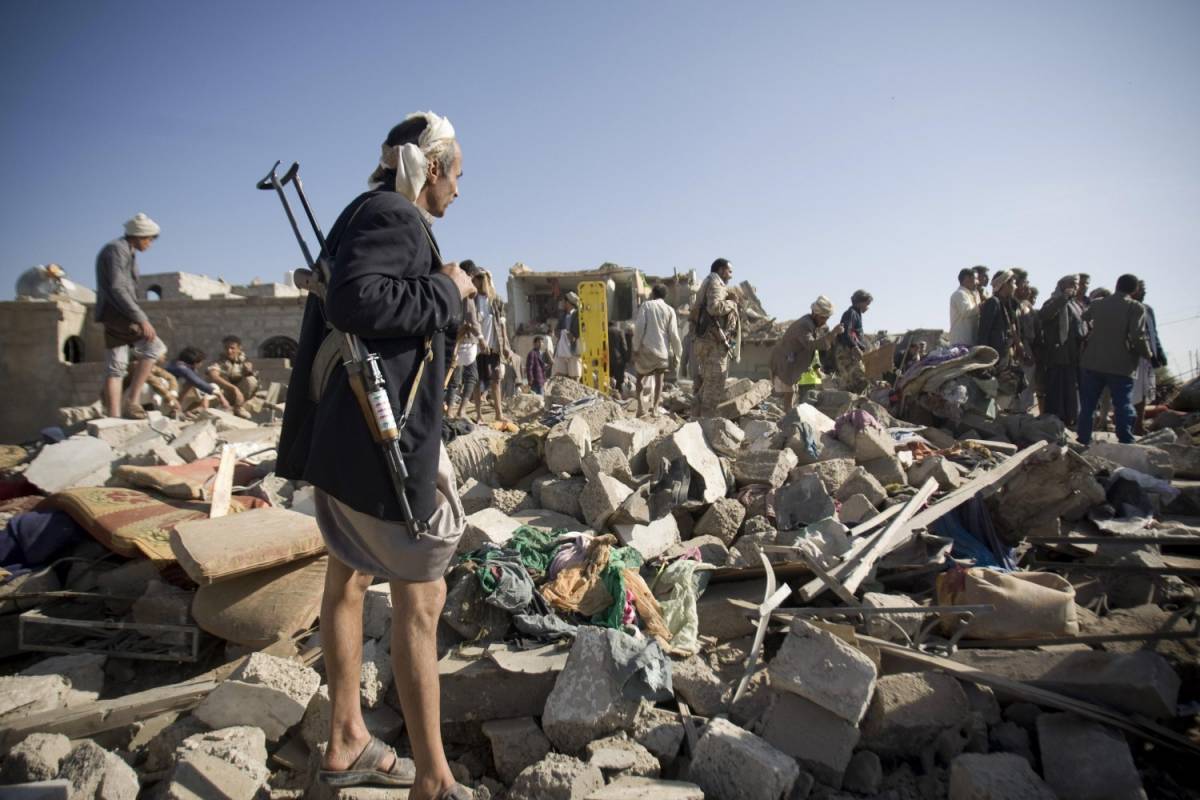 Un miliziano houthi cerca sopravvissuti sotto le macerie vicino all'aeroporto di Sana'a