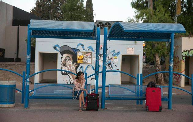 Una donna aspetta alla fermata dell'autobus in Israele