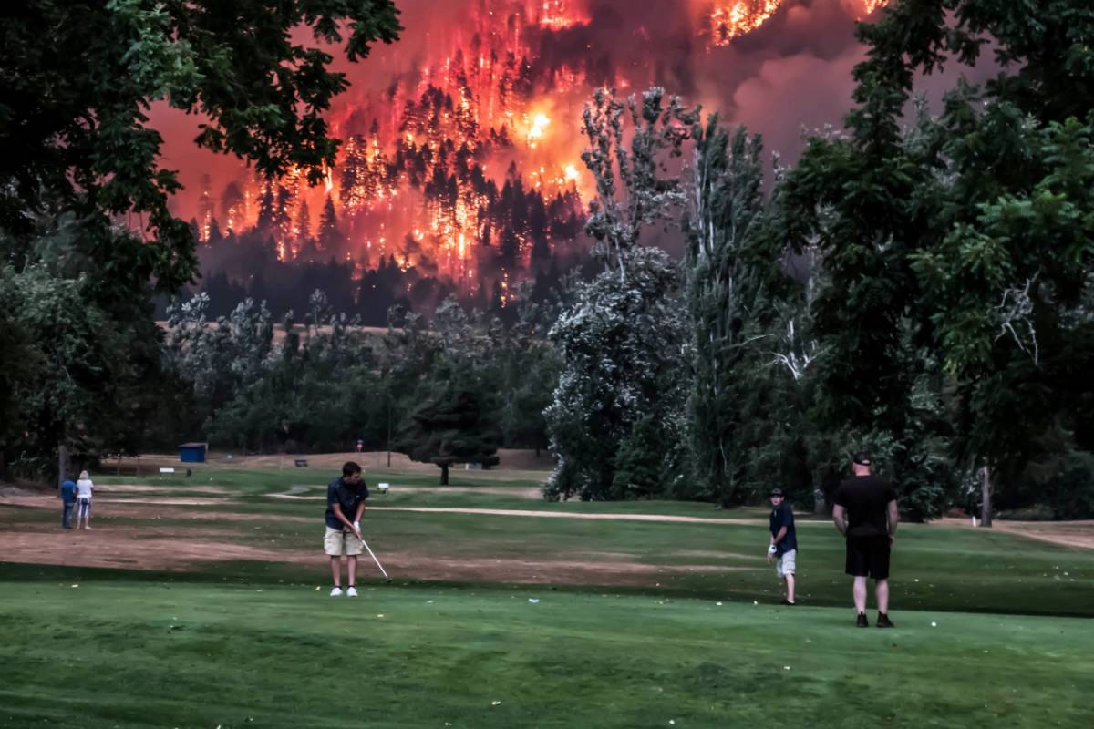 Giocano a golf durante l'incendio: metafora del cambiamento climatico