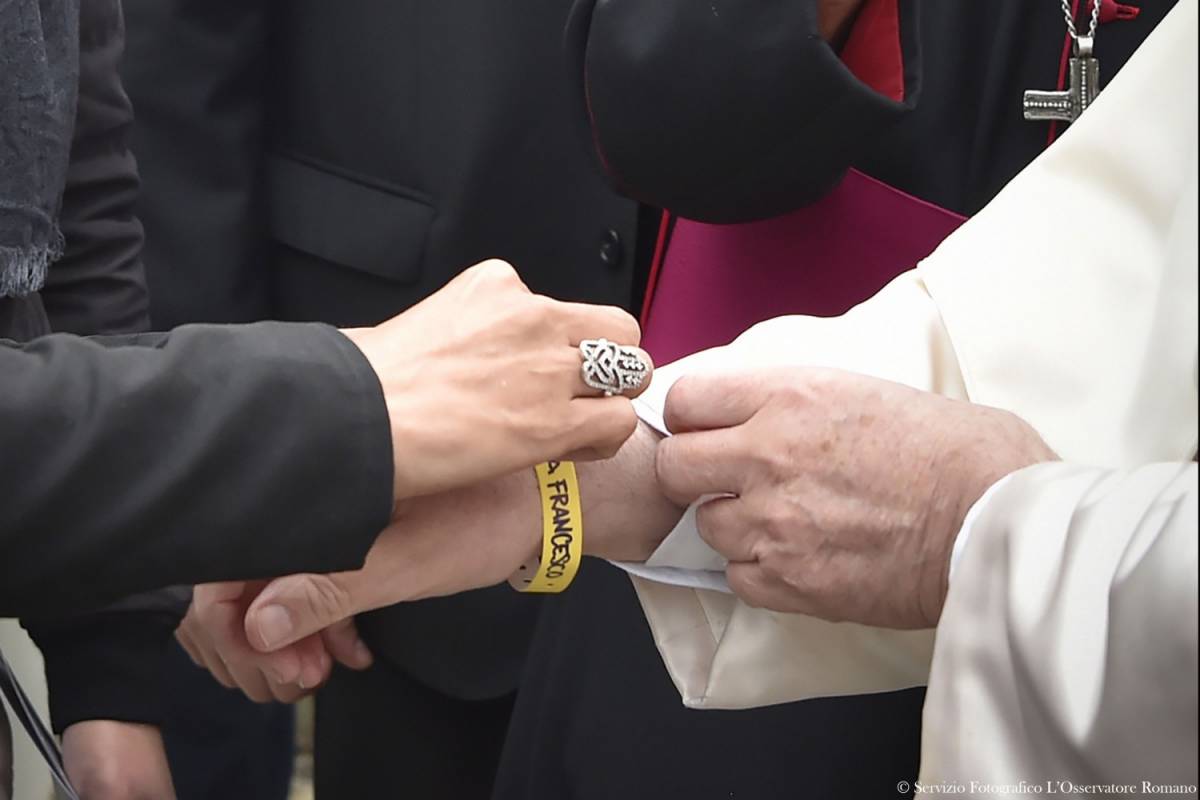 Al papa il bracciale dei migranti. E loro: "Dacci i documenti"