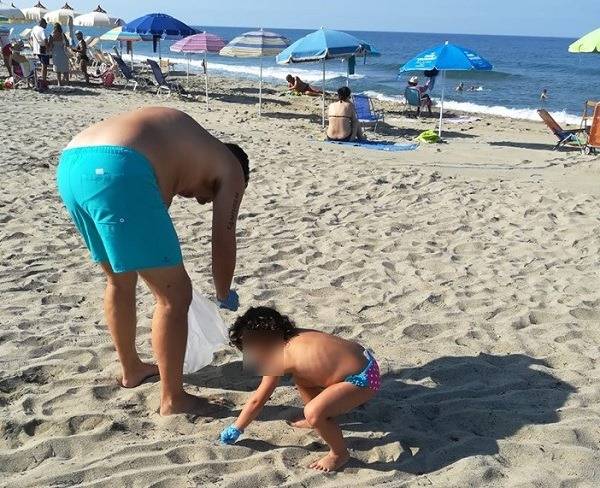 Famiglia napoletana in vacanza ripulisce la spiaggia dai rifiuti