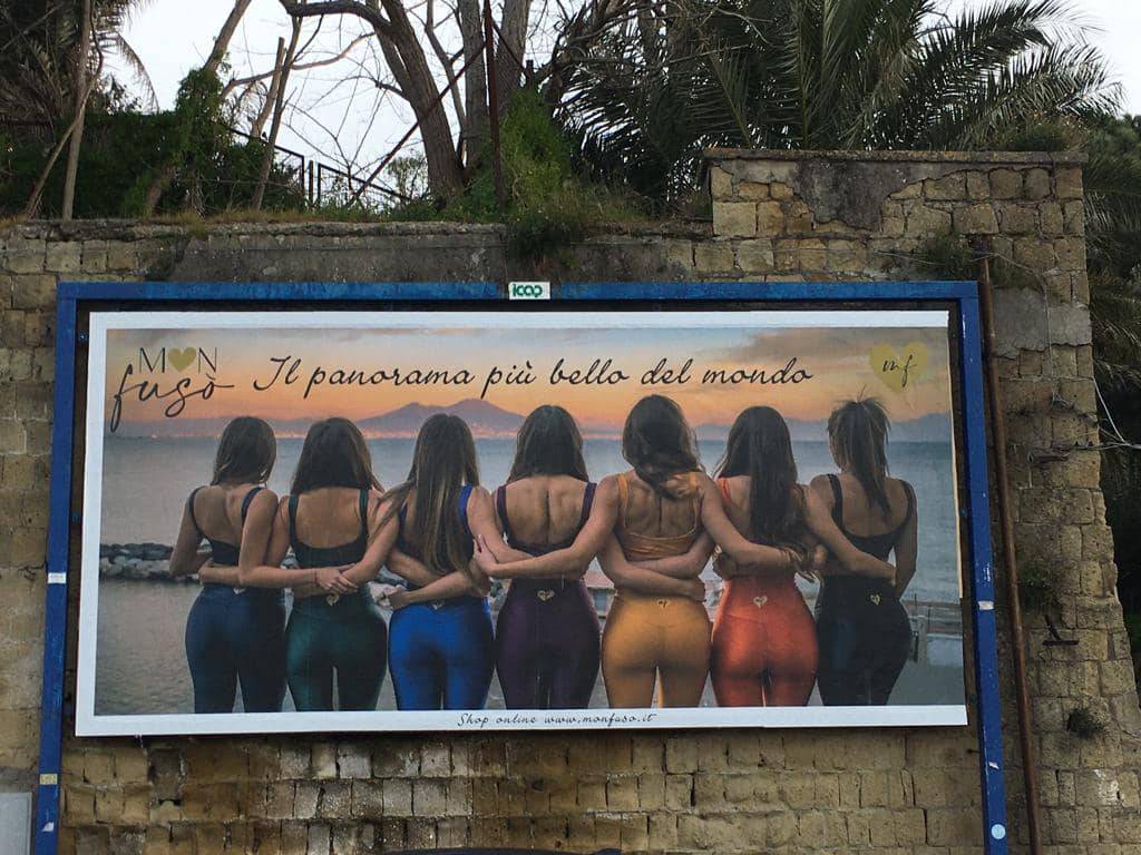 Lato B ben in vista nel cartellone pubblicitario: è polemica per l’immagine sessista
