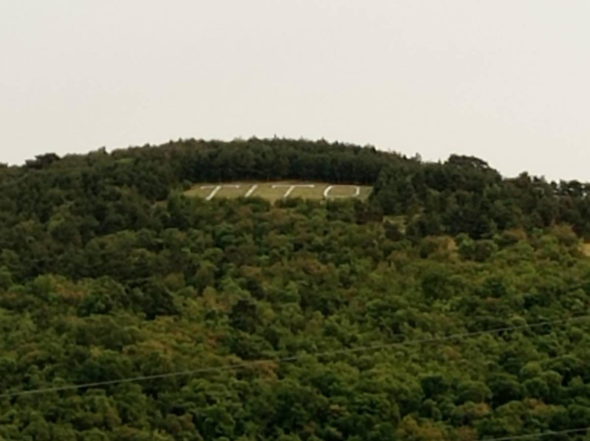 Sfregio sloveno ai martiri delle foibe, sulla collina appare la scritta "Tito"