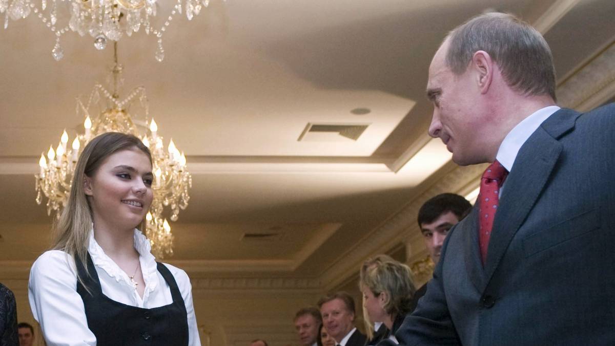Putin stringe la mano alla ginnasta russa Alina Kabaeva, sua presunta amante e madre di 4 figli attribuiti alla sua relazione con il presidente russo.