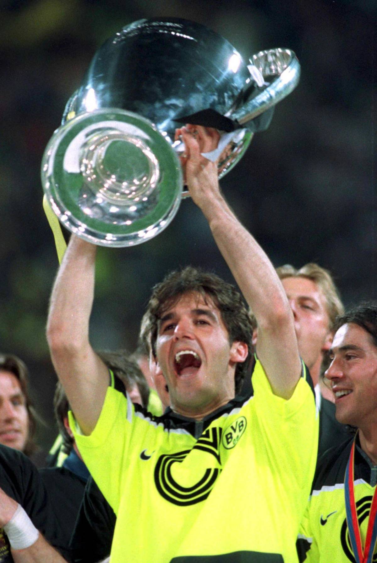 Il giocatore del Borussia Dortmund, Karl-Heinz Riedle, autore di una doppietta per la sua squadra, esulta innalzando la Coppa dei Campioni, 29 maggio 1997 a Monaco, contro la Juventus