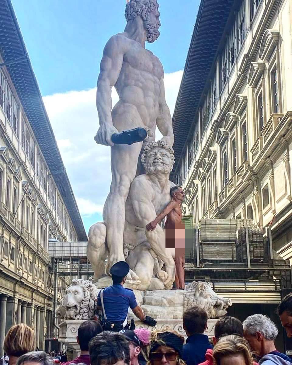 Firenze, uomo nudo si arrampica sulla statua in piazza Signoria. Sul corpo la scritta "censurato"