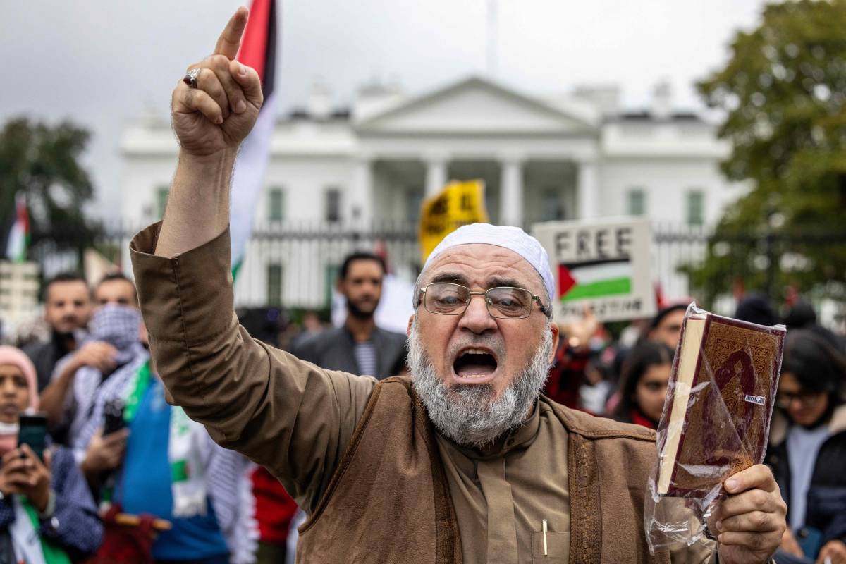 Un uomo mostra il corano e protesta contro Israele davanti alla Casa Bianca