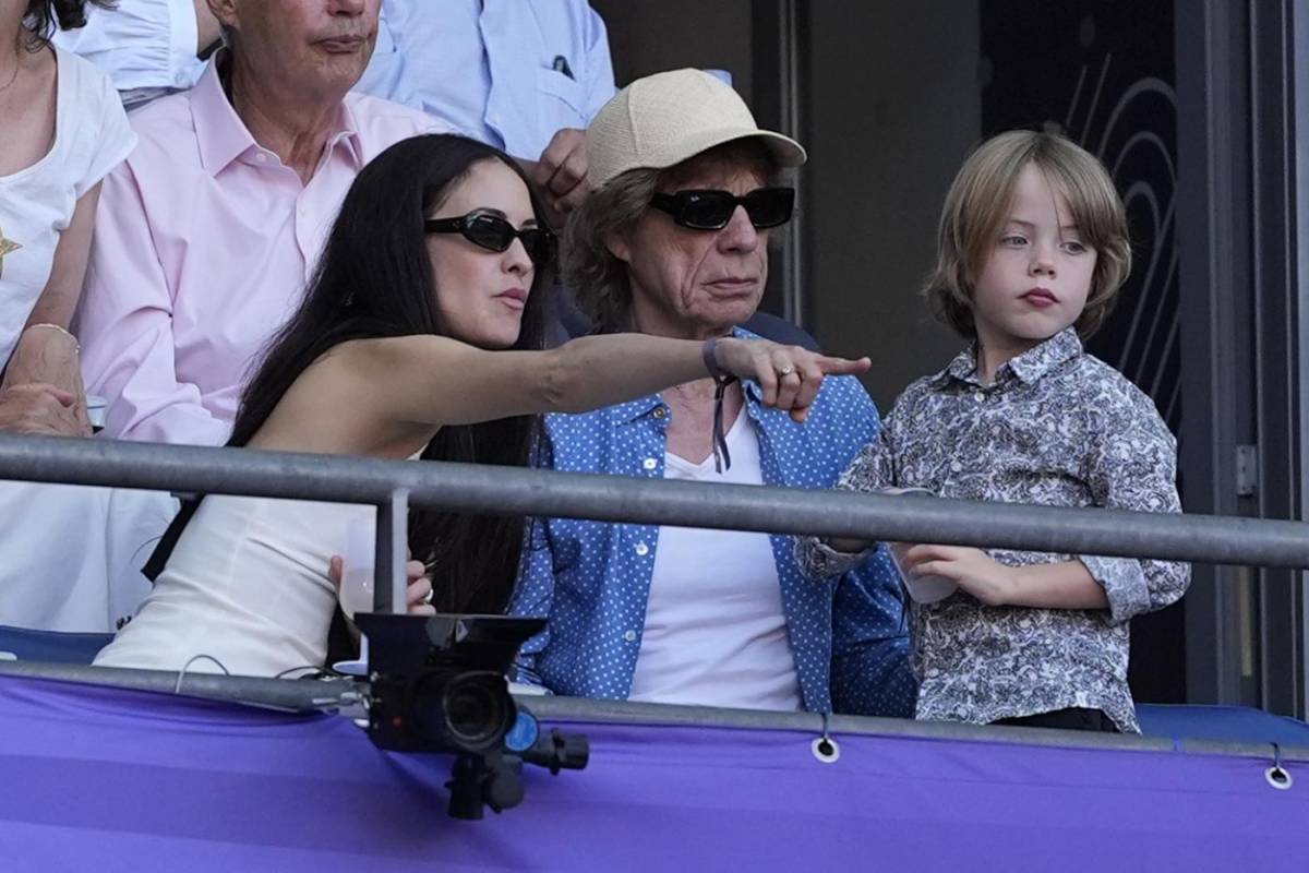 Il rocker Mick Jagger (al centro) insieme alla compagna Melanie (a sinistra) e all'ultimo dei suoi 8 figli Devi (a destra)