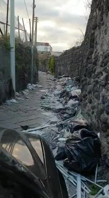 I rifiuti che invadono la carreggiata lungo la strada